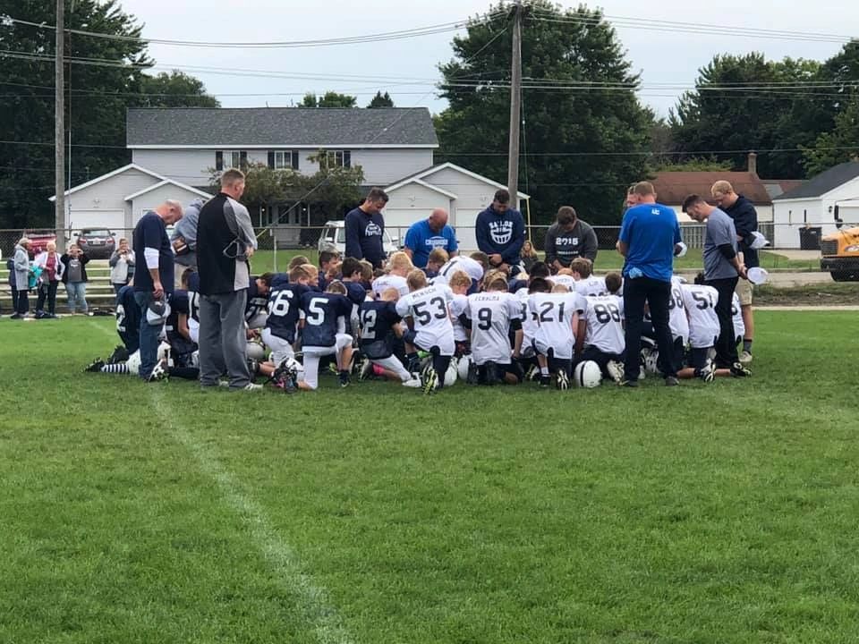 Sailors youth football team huddle in neighborhood