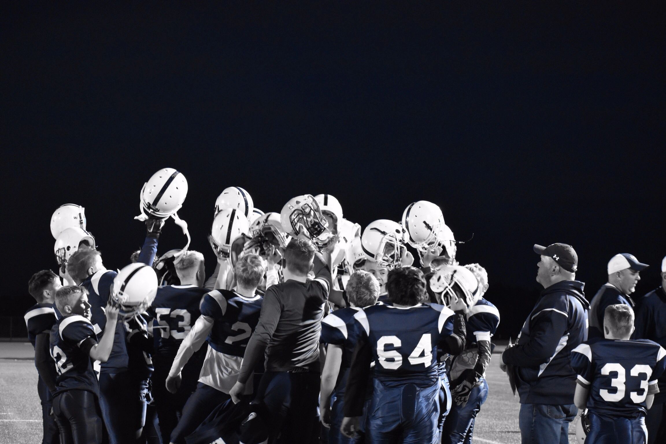 Sailor Youth Football team huddle on the field at night